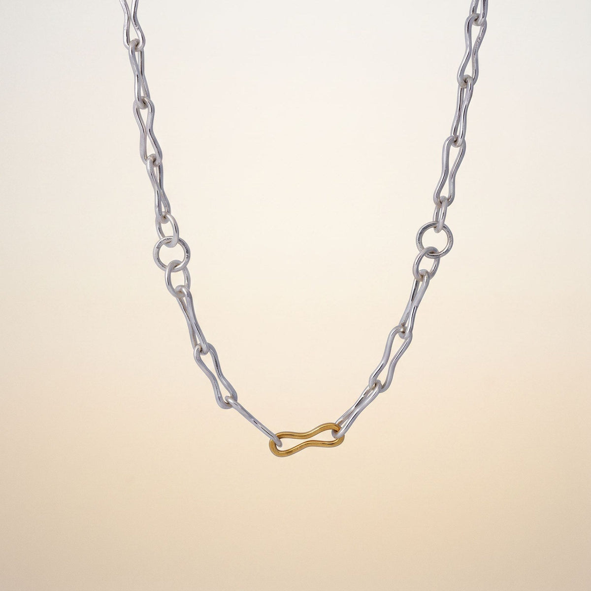 Necklace with a blue pendant hanging between white orchids against a dark background