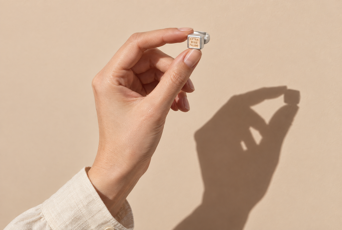 Hand holding a finished sterling silver ring up to the light — Golden Horn keepsake