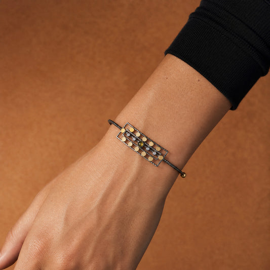 Ancient Queen Gemstone Bracelet worn on the wrist, gold discs and olive tourmaline on oxidised silver – handmade jewellery by Golden Horn