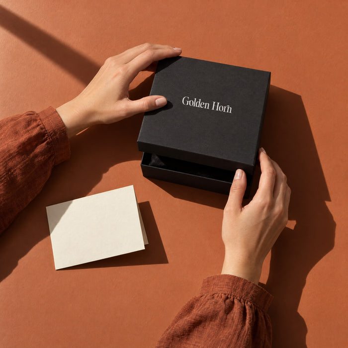 Hands closing the lid of a Golden Horn gift box