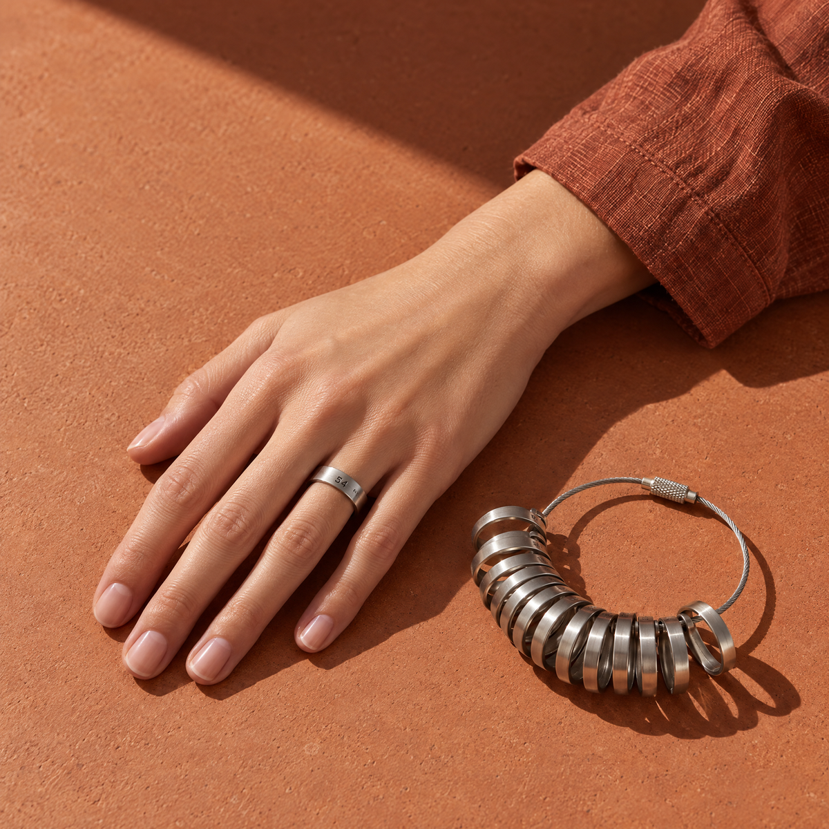 Hand wearing a ring-sizer gauge beside a set of sizing bands — Golden Horn ring size guide