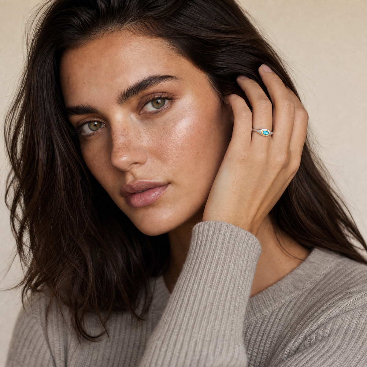 March Aquamarine Birthstone Ring worn on hand, model Erin in grey knit - Golden Horn Jewellery