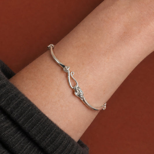 Ouroboros Snake Silver Bracelet worn on the wrist, close-up of the engraved snake head and tail clasp – handmade jewellery by Golden Horn