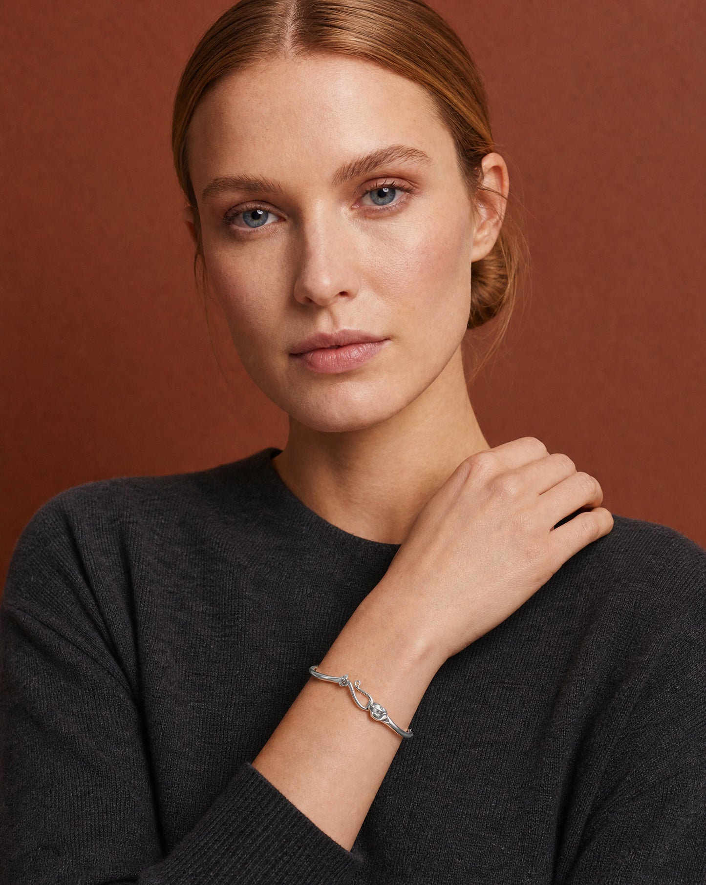 Model wearing the Ouroboros Snake Silver Bracelet with a dark knit – handmade jewellery by Golden Horn