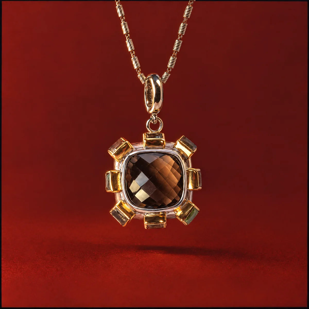 Smoky quartz and citrine pendant necklace against a deep burgundy backdrop