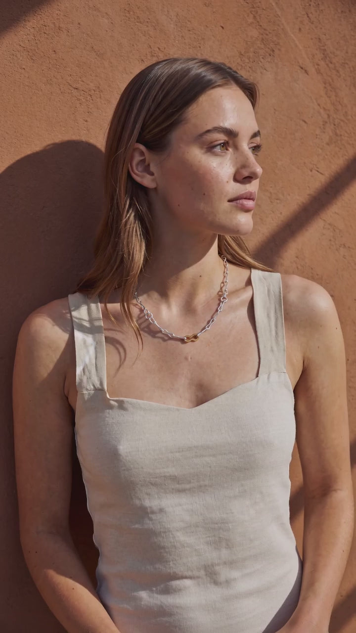 Golden Horn Bicolour Chain Necklace worn by a model against a terracotta wall