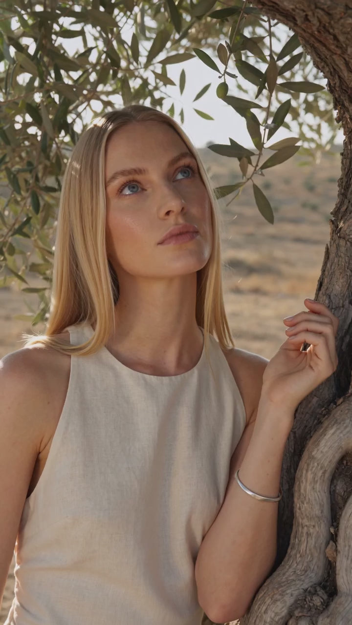 Atia Brushed Silver Cuff Bracelet worn by a model under an olive tree